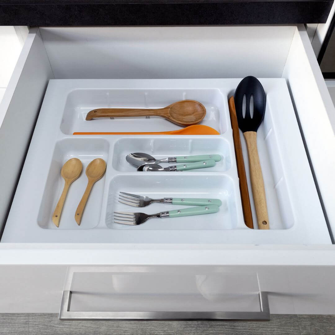 organizador blanco en un cajón con cucharas, tenedores, cucharones, cucharas de madera y demás utensilios de cocina