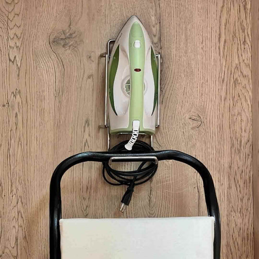 porta plancha instalado con una plancha verde colocada y una tabla de planchas negra con tela blanca